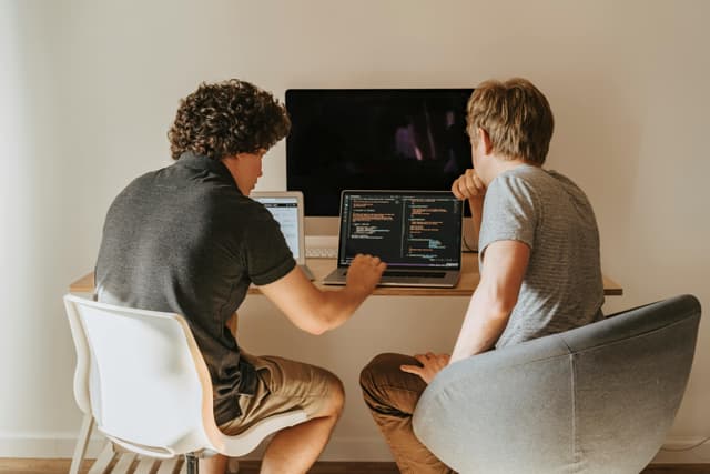 Man in Hoodie Sweater Using a Laptop